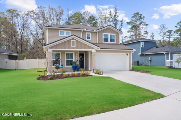 view of front of home with a garage, concrete driveway, a front yard, and fence