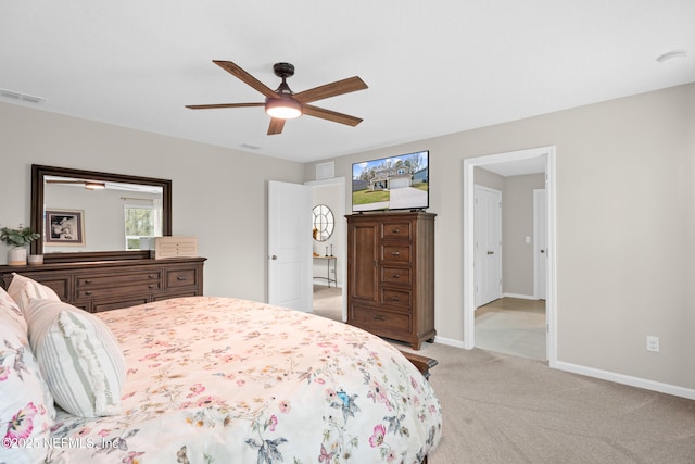 bedroom featuring visible vents, light colored carpet, baseboards, and ceiling fan