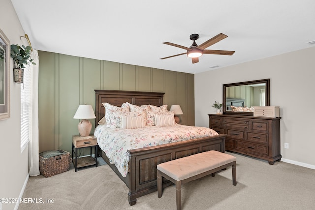 bedroom featuring a ceiling fan, visible vents, baseboards, and light carpet