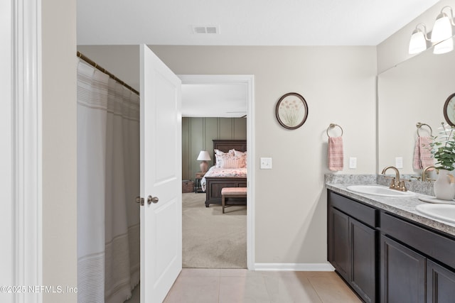 ensuite bathroom with visible vents, double vanity, a sink, tile patterned flooring, and ensuite bathroom