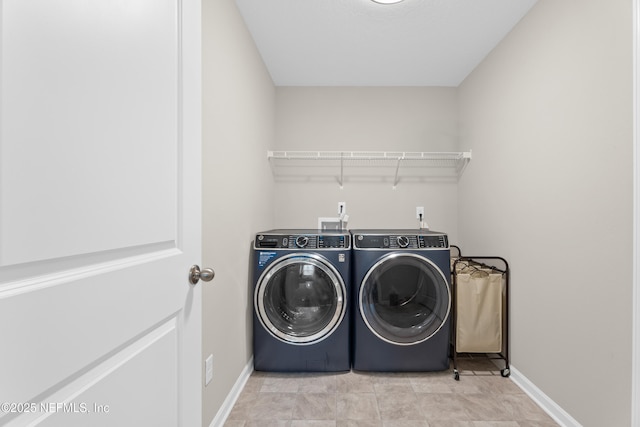 laundry room featuring washer and clothes dryer, laundry area, and baseboards