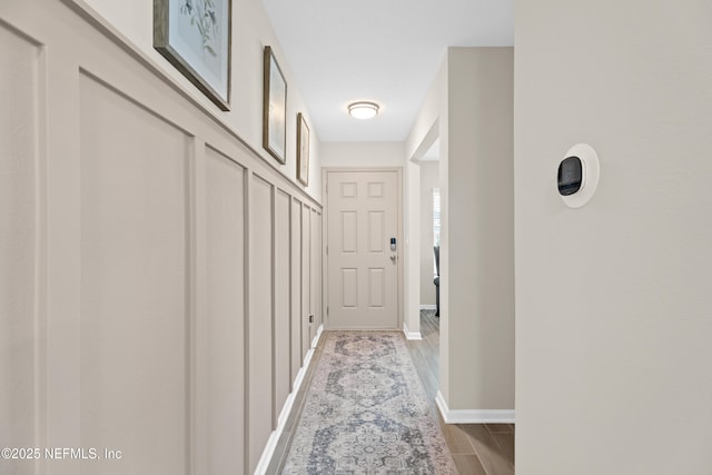 hallway with wood finish floors and baseboards