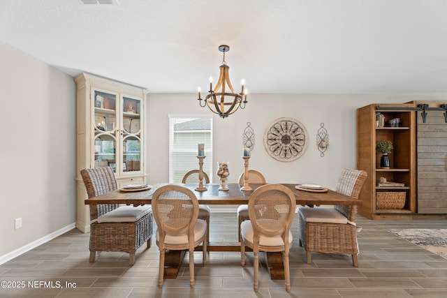 dining room featuring a notable chandelier, visible vents, baseboards, and wood tiled floor