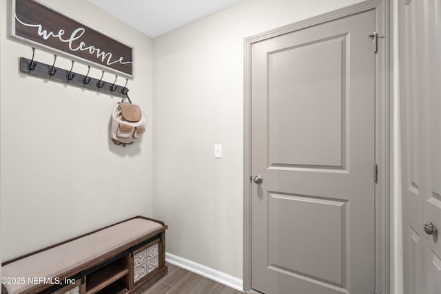 mudroom featuring baseboards and dark wood-style flooring