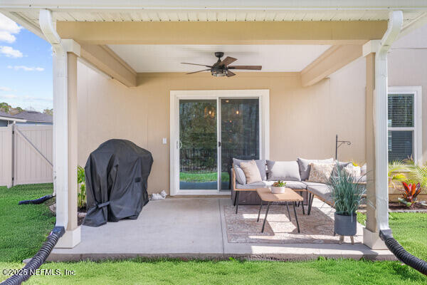 view of patio with outdoor lounge area, area for grilling, a ceiling fan, and fence