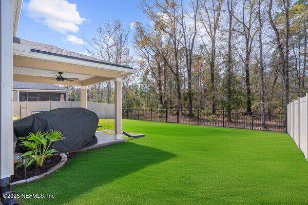 view of yard with a ceiling fan and a fenced backyard