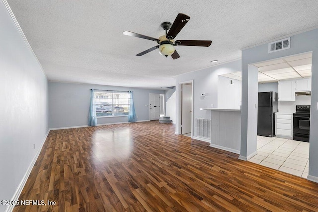 unfurnished living room with a ceiling fan, light wood-style flooring, visible vents, and crown molding