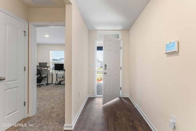 entrance foyer with visible vents, baseboards, and dark wood-type flooring