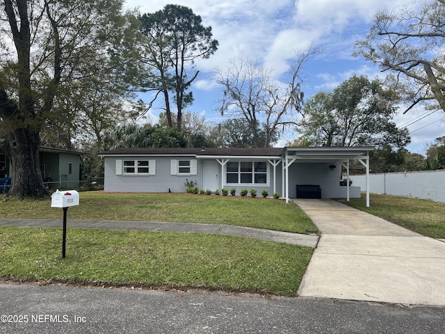 view of front of house featuring a carport, concrete driveway, fence, and a front lawn