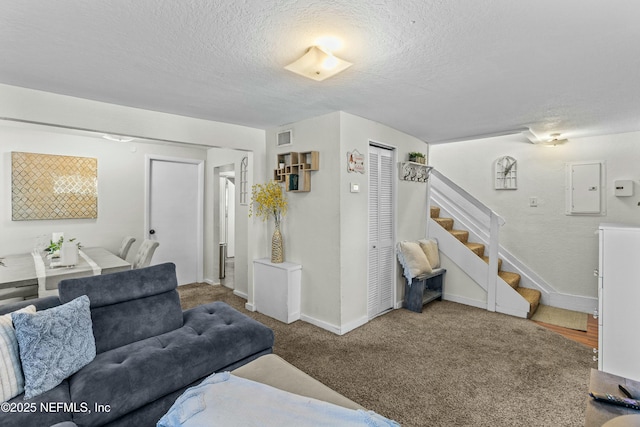810 Calvert St, Jacksonville, FL 32208 - carpeted living room with a textured ceiling, visible vents, baseboards, stairs, and electric panel