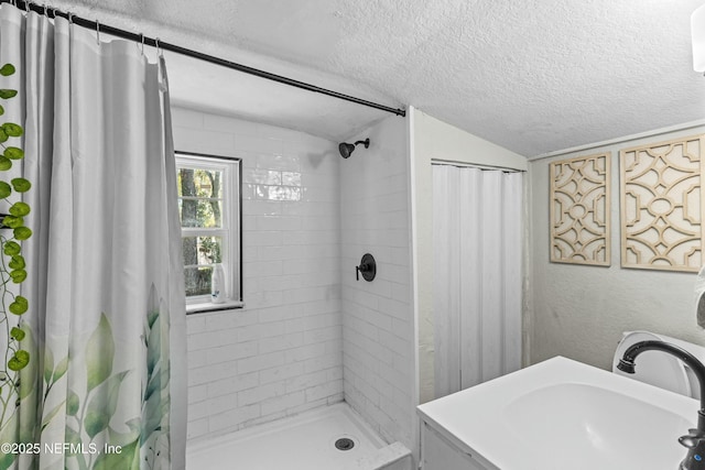 810 Calvert St, Jacksonville, FL 32208 - bathroom featuring lofted ceiling, a textured wall, a sink, a textured ceiling, and tiled shower