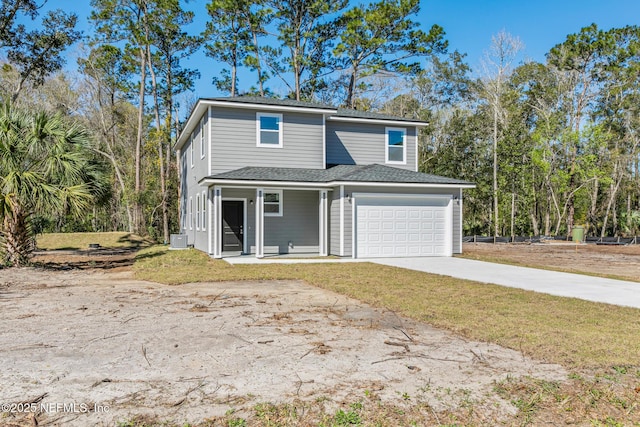 view of front of house featuring a garage, a front yard, covered porch, and driveway