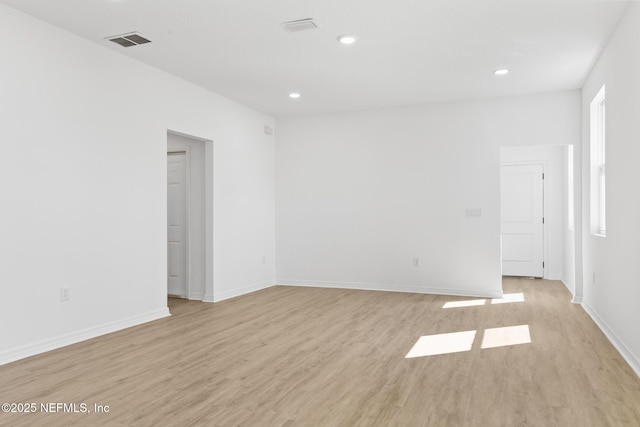 empty room with recessed lighting, visible vents, baseboards, and light wood finished floors