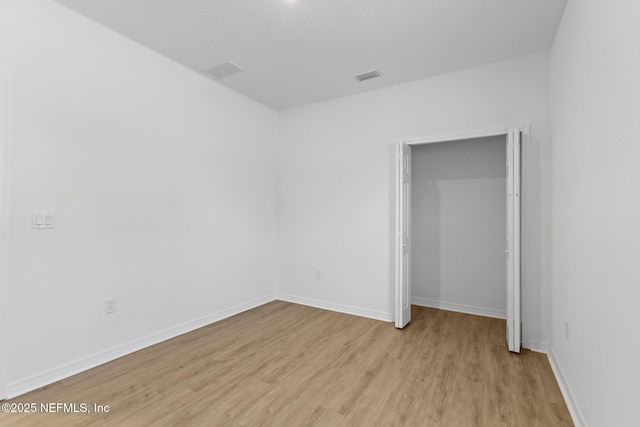 unfurnished bedroom with visible vents, baseboards, and light wood-style floors