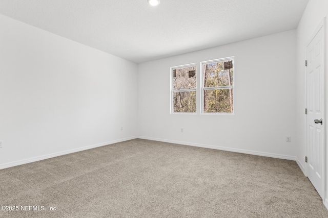 carpeted empty room with baseboards