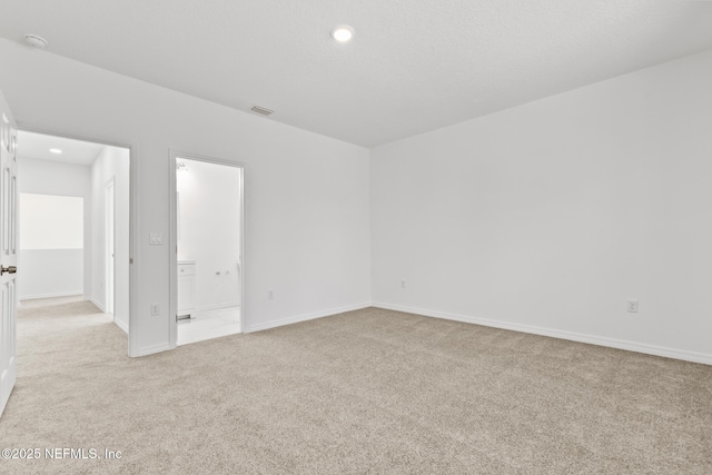 empty room featuring recessed lighting, visible vents, light colored carpet, and baseboards