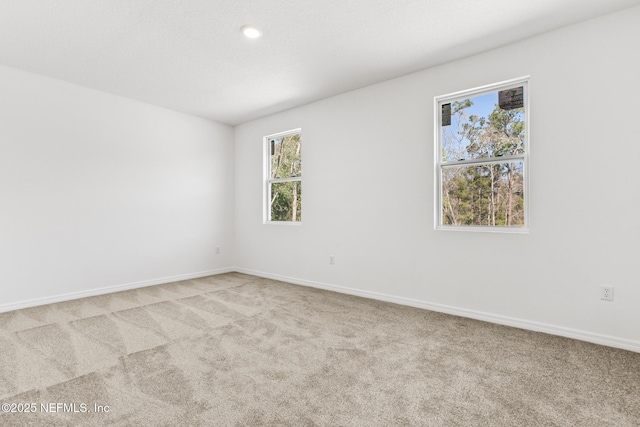 carpeted empty room featuring baseboards