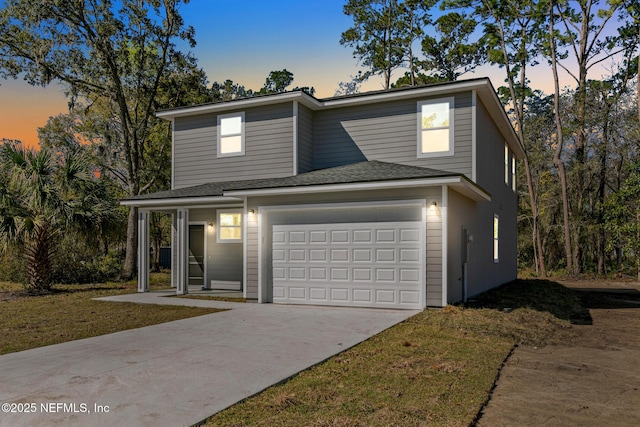 view of front of house with driveway, an attached garage, and roof with shingles