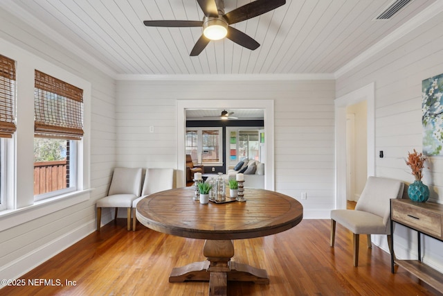 dining room featuring wood finished floors, a ceiling fan, visible vents, baseboards, and wooden ceiling