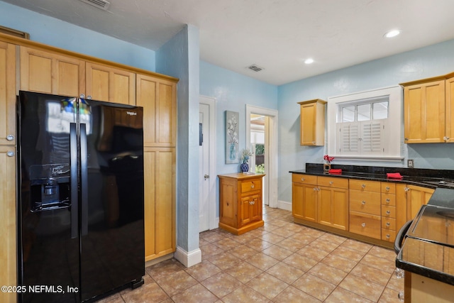 kitchen featuring dark countertops, visible vents, and black fridge
