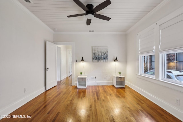 interior space with crown molding, baseboards, and wood-type flooring