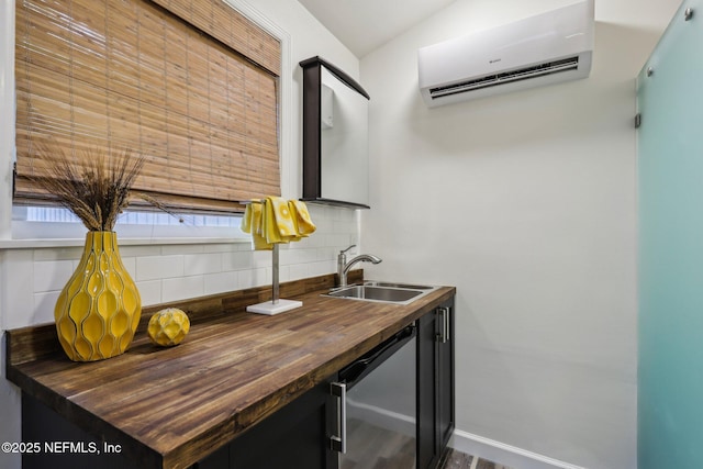 interior space featuring baseboards, butcher block countertops, a wall mounted air conditioner, decorative backsplash, and a sink