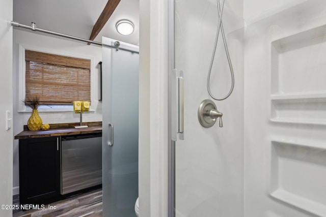 bathroom featuring tasteful backsplash, a shower stall, toilet, and wood finished floors