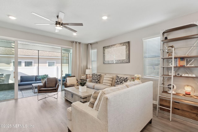 living room with a ceiling fan, recessed lighting, and wood finished floors