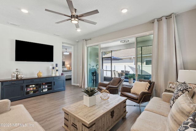 living area featuring visible vents, a ceiling fan, light wood-style flooring, and recessed lighting