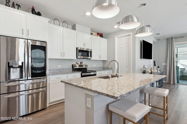 kitchen featuring white cabinets, stainless steel appliances, and a sink