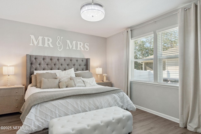 bedroom with baseboards and wood finished floors