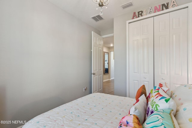 bedroom featuring a closet, wood finished floors, and visible vents