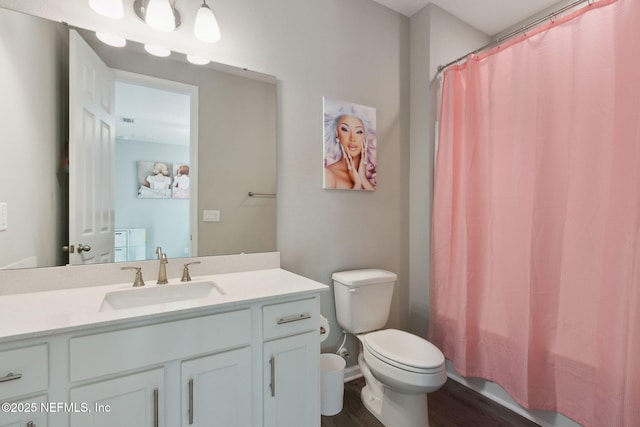 full bath featuring toilet, shower / bath combo with shower curtain, wood finished floors, and vanity