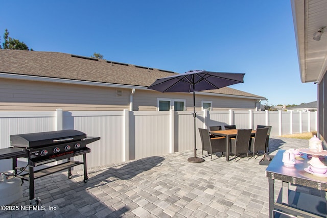 view of patio featuring outdoor dining space, a fenced backyard, and area for grilling