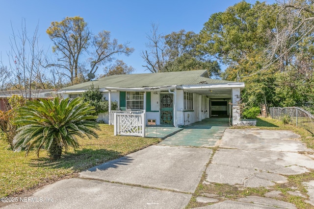 bungalow-style home featuring stucco siding, an attached carport, concrete driveway, and fence