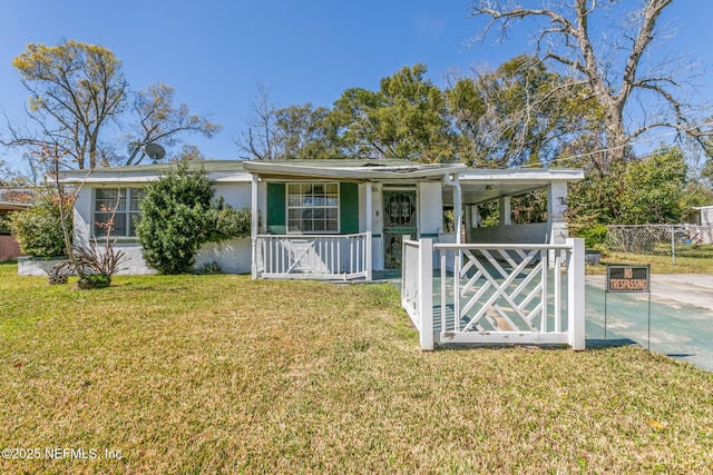 view of front facade with an attached carport, a front yard, a porch, stucco siding, and concrete driveway