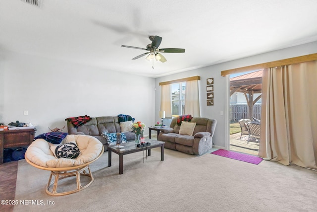 carpeted living area with ceiling fan