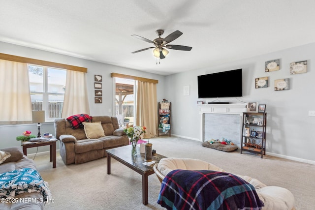 living room featuring ceiling fan, baseboards, and carpet floors