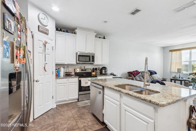 kitchen featuring visible vents, appliances with stainless steel finishes, open floor plan, and a sink