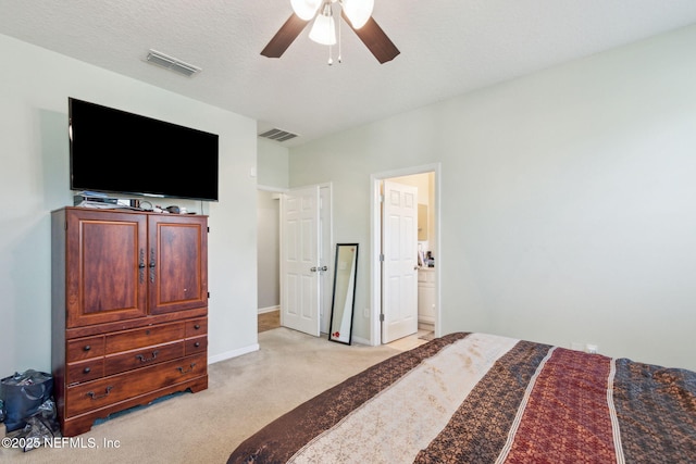 bedroom featuring visible vents, baseboards, light colored carpet, and a textured ceiling