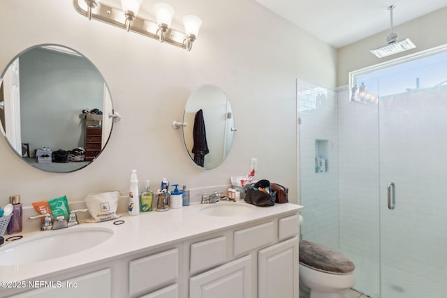 bathroom featuring a sink, toilet, double vanity, and a shower stall