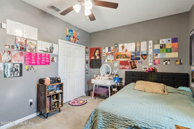 carpeted bedroom with baseboards, visible vents, a closet, and ceiling fan