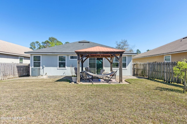 rear view of house featuring a fenced backyard, a gazebo, a yard, central AC unit, and a patio area