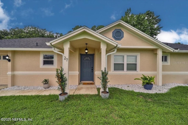 ranch-style house with stucco siding, an attached garage, a front lawn, and roof with shingles