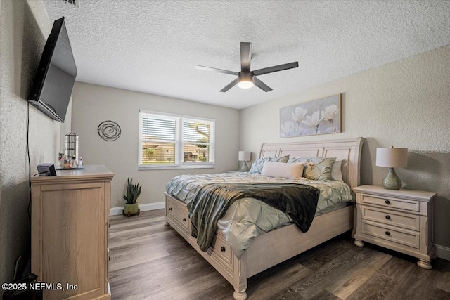 bedroom with dark wood-type flooring, a textured wall, baseboards, and a textured ceiling