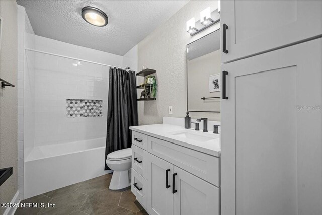 full bathroom featuring vanity, toilet, a textured wall, and a textured ceiling