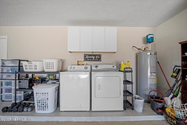 washroom with independent washer and dryer, cabinet space, water heater, and a textured ceiling