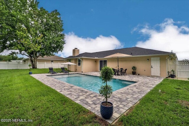 view of pool featuring a fenced in pool, a patio, a lawn, and a fenced backyard