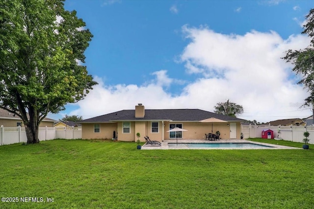 rear view of house featuring a fenced in pool, a patio, a lawn, and a fenced backyard