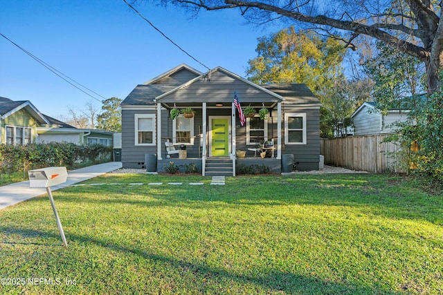 bungalow-style house featuring a porch, a front lawn, and fence